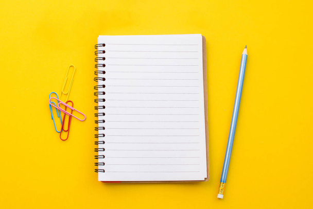 empty paper of notebook eyeglasses and pencil on color background. - Fotó, kép