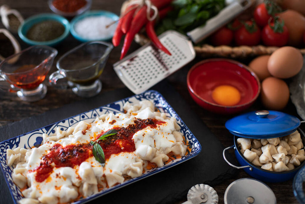 Турецкие равиоли манти с мясом, йогуртом, маслом и красным перцем
.  - Фото, изображение