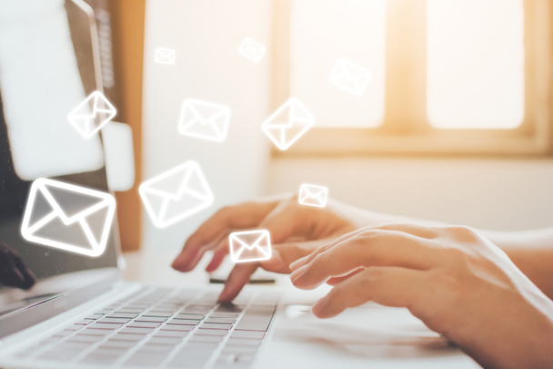 Email marketing a newsletter koncept. Ruka muže odesílajícího zprávu a notebook s ikonou e-mailu - Fotografie, Obrázek