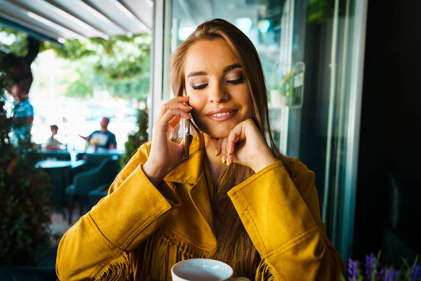 Portrait de jeune belle femme au café restaurant parlant à l'appel téléphonique mobile heureux souriant
 - Photo, image