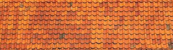 Panorama van een oude rustieke keramische dakpan. Verouderde oranje dakpannen. - Foto, afbeelding