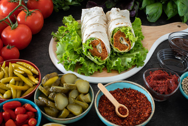 Cig kofte (ωμά κεφτεδάκια στα τουρκικά) με μαρούλι, ντομάτα, τουρσί και λεμόνι, ζεστό Chee kofta. Τουρκικά τοπικά ωμά τρόφιμα cigkofte  - Φωτογραφία, εικόνα