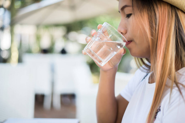 Жінка п'є зі склянки води. Пийте воду для здорового
. - Фото, зображення