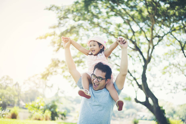 Father gives her daughter piggyback, happy time family. - 写真・画像