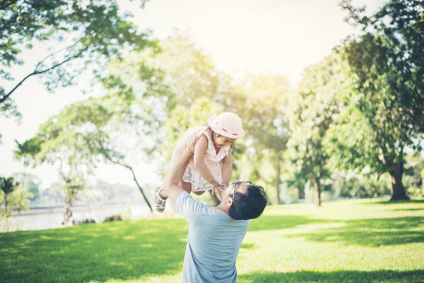 Father throws his daughter up high against, happy time family. - Photo, Image