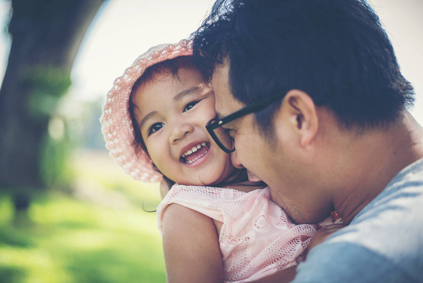 Kleines Mädchen umarmt Hals ihres Papas, Vater spielt mit Tochter glückliche Familienzeit. - Foto, Bild