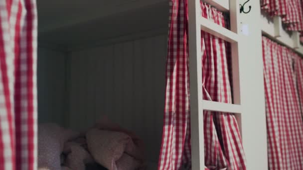 Jonge vrouw in gemeenschappelijke hostel kamer sluit gordijnen en gaat slapen - Video
