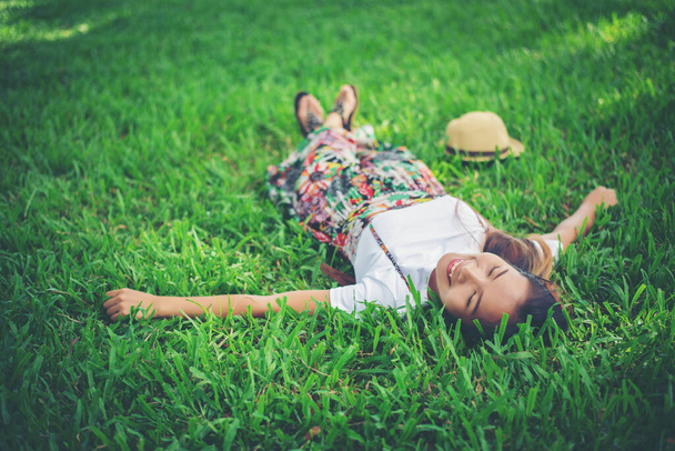 Młoda kobieta leżąca na trawie. czas relaksu. - Zdjęcie, obraz
