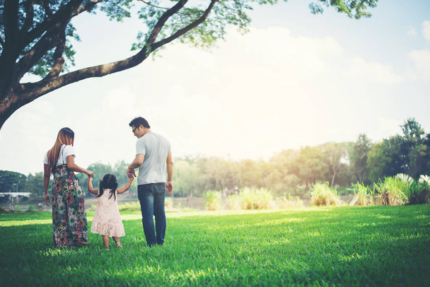 Ευτυχισμένη οικογένεια στο πάρκο, ο πατέρας και η μητέρα παίζουν με την κόρη, να χαλαρώσετε οικογενειακές στιγμές - Φωτογραφία, εικόνα