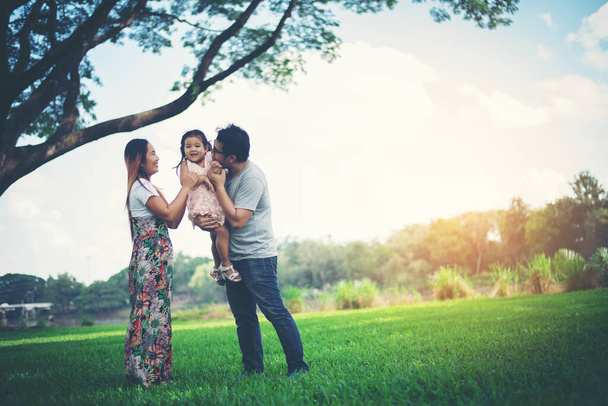 Ευτυχισμένη οικογένεια στο πάρκο, ο πατέρας και η μητέρα παίζουν με την κόρη, να χαλαρώσετε οικογενειακές στιγμές - Φωτογραφία, εικόνα