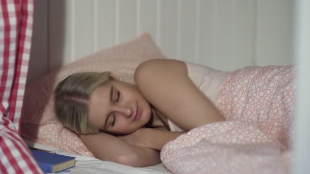 Mujer joven duerme en acogedora habitación del albergue - Imágenes, Vídeo