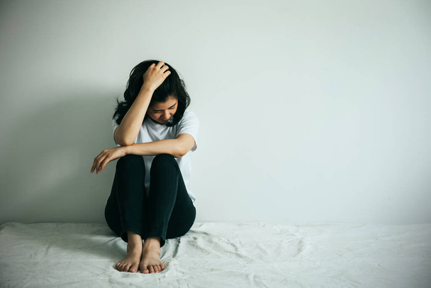 The depression woman  hug her knee and cry. Sad woman sitting alone in a empty room.  - Zdjęcie, obraz