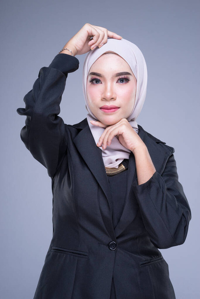 Μισού μήκους πορτραίτο μιας ελκυστικής μουσουλμάνας γυναίκας που φοράει επαγγελματική ενδυμασία και χιτζάμπ με ανάμεικτες πόζες που απομονώνονται σε γκρι φόντο. Για εικόνα cut-out για ομορφιά, επιχείρηση ή χρηματοδότηση. - Φωτογραφία, εικόνα