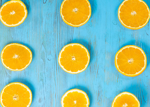 arance tagliate ad anelli su fondo di legno blu
 - Foto, immagini