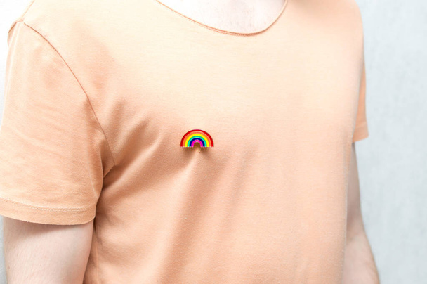 hombre en una camiseta tiene un icono de arco iris, un símbolo LGBT. Primer plano. Concepto
 - Foto, imagen