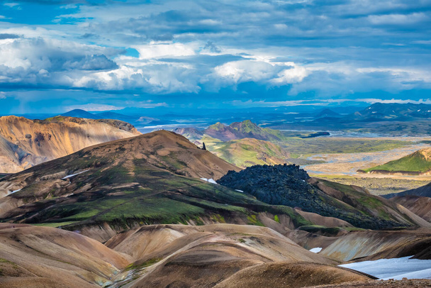 Dramatycznie piękne i surrealistyczne krajobrazy Landmannalaugar na skraju pola lawy Laugahraun w rezerwacie przyrody Fjallabak na wyżynach Islandii. Oznakowanie północnego końca słynnego szlaku turystycznego Laugavegur. - Zdjęcie, obraz
