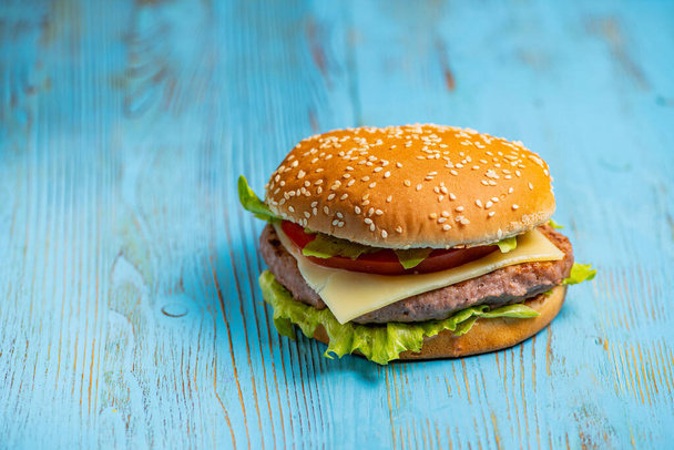 burger σε μπλε ξύλινο φόντο - Φωτογραφία, εικόνα