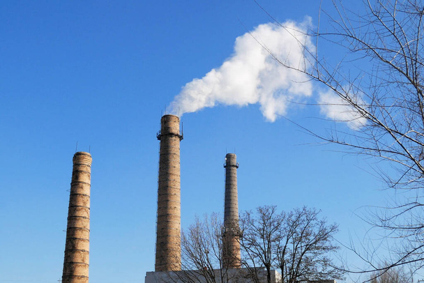 tubos de planta con humo gris en el cielo azul, torres de plantas químicas de la planta de energía nuclear contra el cielo azul - Foto, Imagen