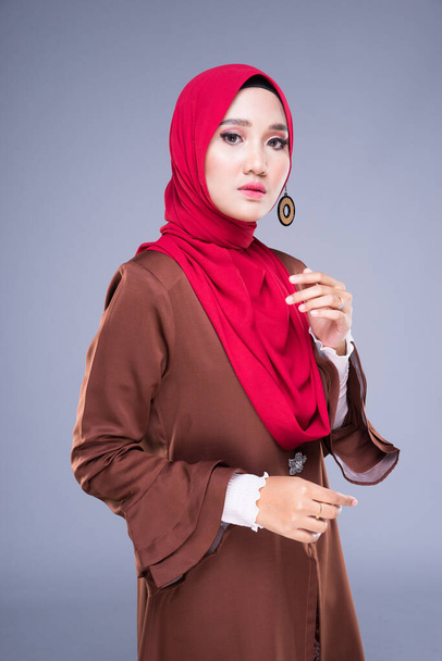 Félhosszú portré egy gyönyörű női modell visel egy modern kebaya ruha és hidzsáb, egy életmód ruházat a muszlim nők elszigetelt szürke háttér. Szépség és hidzsáb divat koncepció. - Fotó, kép