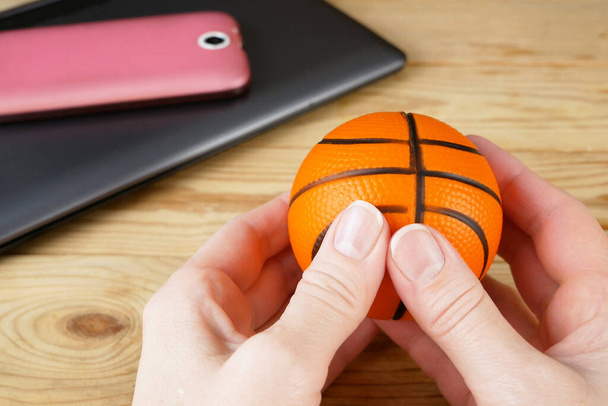 digitální detoxikační koncept, osoba hrát s malým míčkem v ruce a notebook s mobilním telefonem pozadí - Fotografie, Obrázek