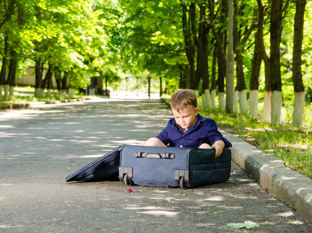 νεαρό αγόρι που παίζει με ένα ανοικτό βαλίτσα - Φωτογραφία, εικόνα