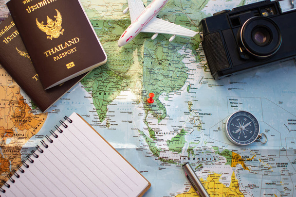 broche sur la carte de localisation pour le plan de voyage avec caméra boussole passeport et ordinateur portable
. - Photo, image