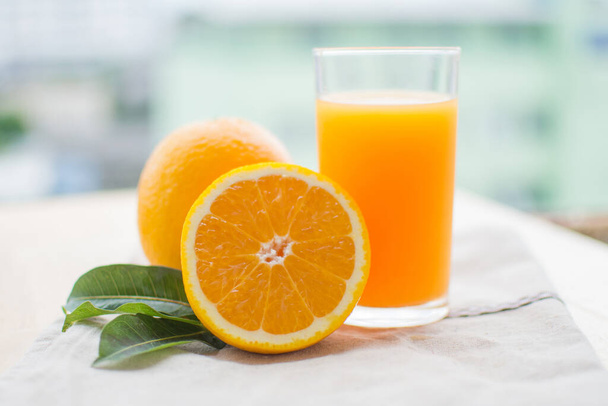 narancslé és narancslé levelekkel a fa asztalon a napsütéses napon. lágy fókusz. - Fotó, kép