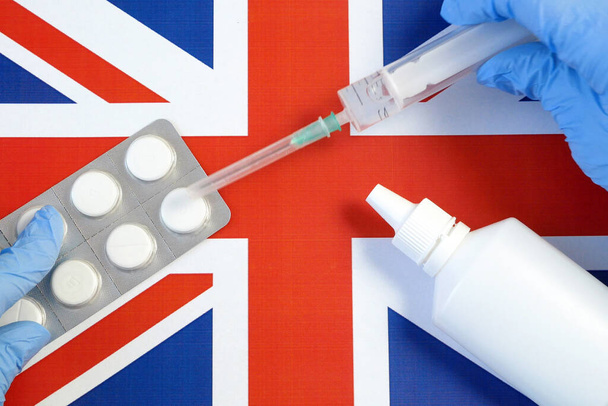 Covid - 19, koronavirüs konsepti. Birleşik Krallık bayrağında ilaç ve İngiltere 'de koronavirüs salgını. - Fotoğraf, Görsel