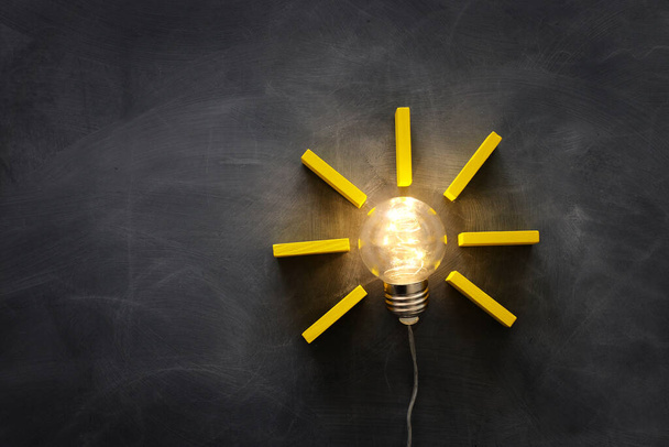 Education concept image. Creative idea and innovation. Light bulb as metaphor over blackboard - Photo, Image