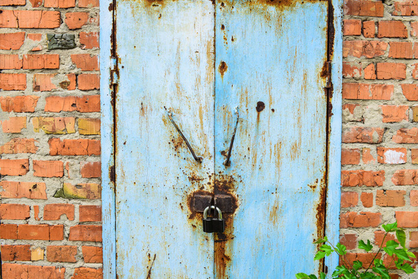 Metalen deur textuur. Grunge ijzeren poort achtergrond. Veiligheidsarchitectuur patroon. Stalen vintage stijl huisbescherming. Weerbestendig lekkende verf staalconstructie - Foto, afbeelding