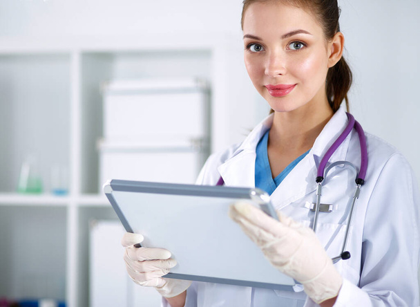 Woman doctor standing with folder at hospital - Photo, image