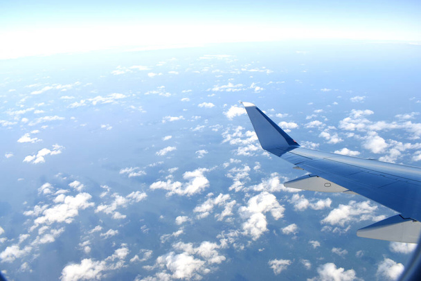 Крило літака, що летить над хмарами в блакитному небі, вид з вікна літака
 - Фото, зображення