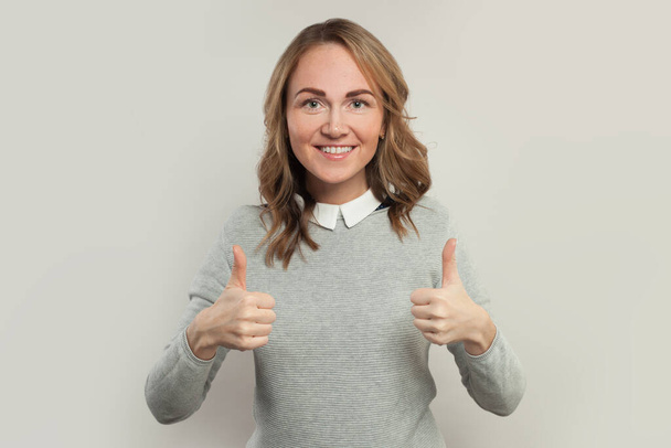 Happy woman showing thumb up and smiling on white - Foto, afbeelding