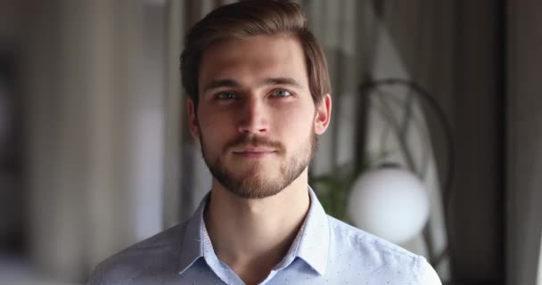 Smiling bearded millennial professional businessman looking at camera, closeup - Кадри, відео