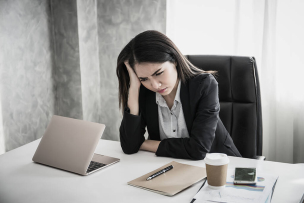 Mujeres con estrés en la cabeza mientras piensan con un nuevo proyecto en el lugar de trabajo
 - Foto, Imagen