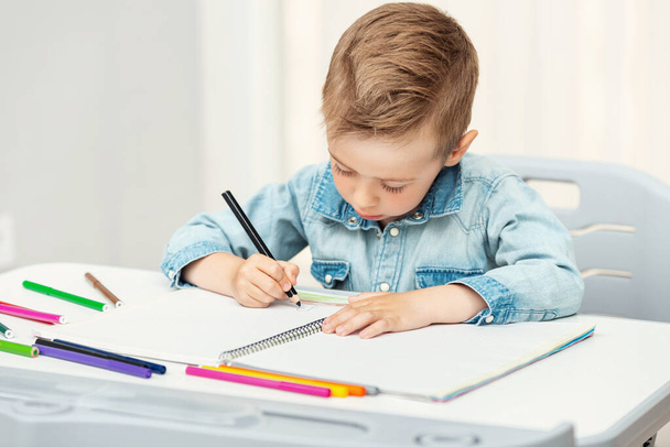 Portret chłopca rysującego kolorowymi ołówkami - Zdjęcie, obraz