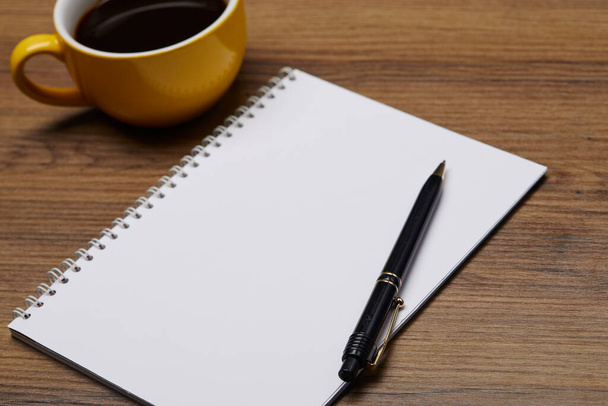empty notebook with pen and cup of coffee on table - Photo, Image