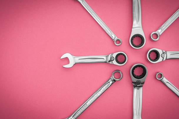 Set of wrenches a professional tool for repair and assembly of structures, pattern concept on a pink background. - 写真・画像