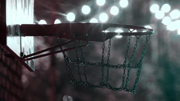 Μπάσκετ μπάλα να πάρει στο στεφάνι για υπαίθρια παιδική χαρά τη νύχτα σε φωτεινά φώτα - Πλάνα, βίντεο