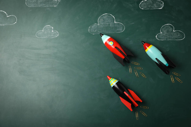 Bright toy rockets and drawings on chalkboard, flat lay with space for text. Back to school - Фото, зображення