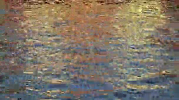 Goldene Reflexion des Sonnenlichts auf der Oberfläche des blauen Wasserflusses, wodurch schöne Wellen, Textur und rhythmische Muster entstehen. - Filmmaterial, Video
