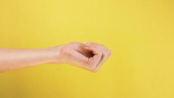 Come here or come on gesture. female hand on yellow background, beckoning and inviting gesture isolated - Filmagem, Vídeo