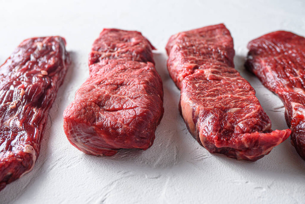 Raw organic denver steak in front of machete denver cuts marble beef on white background - Fotografie, Obrázek