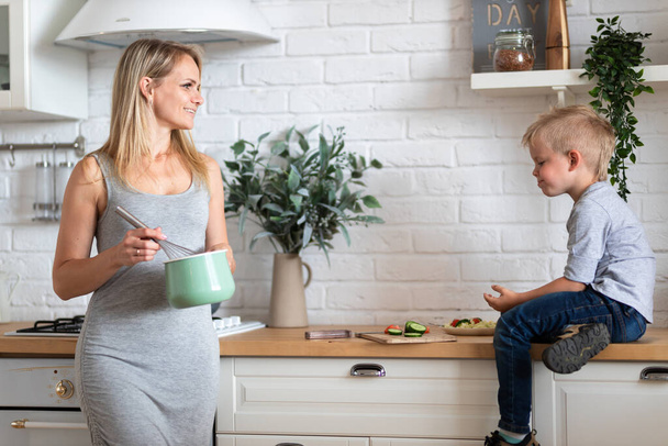 blonde family mother and son are cooking on kitchen at home - Fotoğraf, Görsel
