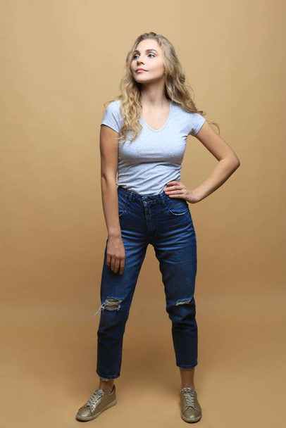 Full length photo of charming young woman in casual wear over beige background - Zdjęcie, obraz