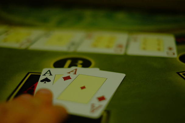 gambling game of poker, the player opens a combination of a pair of aces, casino interior green poker table - Foto, Bild