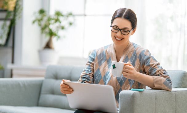 Happy casual beautiful woman working on a laptop at home. - Φωτογραφία, εικόνα