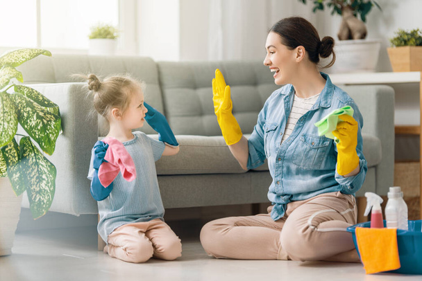 Happy family at home. Mother and daughter doing the cleaning in the house. A young woman and child girl are dusting. Cute little helper. - Fotoğraf, Görsel