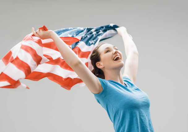 Patriotic holiday. Happy young woman with American flag. USA celebrate 4th of July. - Foto, afbeelding
