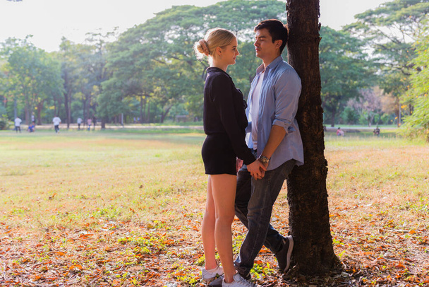 Νεαρό ζευγάρι ερωτευμένο, αγκαλιασμένο στο πάρκο - Φωτογραφία, εικόνα